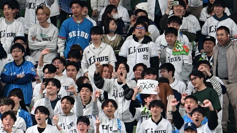 「戒め」の2文字が記された紙を持つファン　©Nanae Suzuki