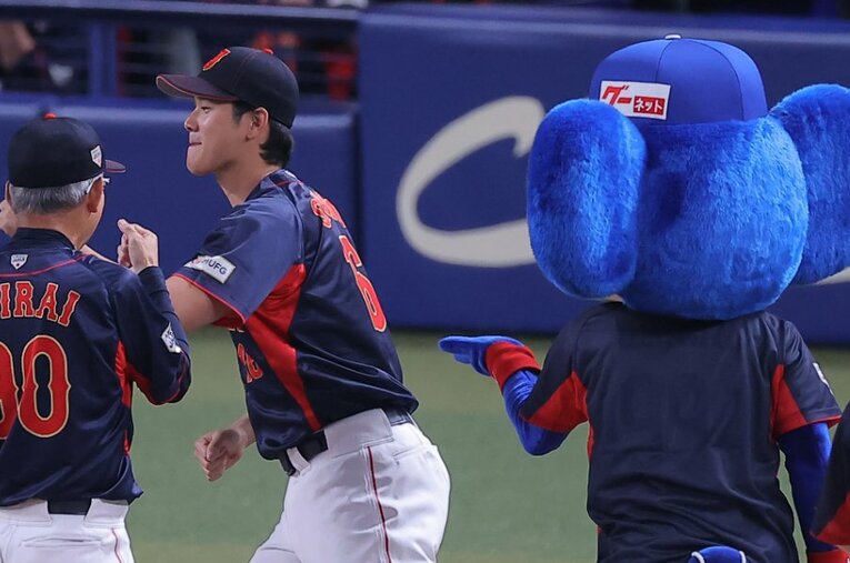 ドアラ（右）のハイタッチを華麗にスルーする大谷翔平 ／ photograph by SANKEI SHIMBUN