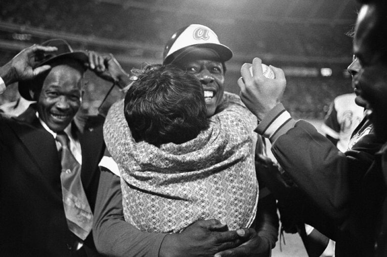 715号を放ち母親に抱きしめられるアーロン。舞台となったアトランタ・フルトン・カウンティ・スタジアムの跡地には、当時の落下点が印されている ／ photograph by Getty Images