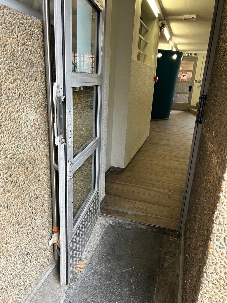 ごみ集積所へのドア。いつもは写真のようにストッパーがあるのだが……この日ごみを出して戻ろうとしたら閉まっていた