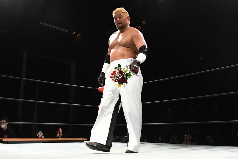 石川入場 金髪、白のロングパンツに花束