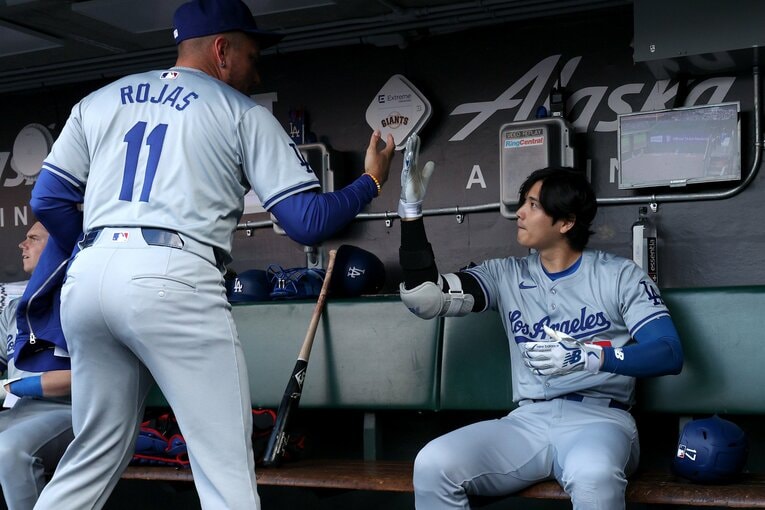ベンチでミゲル・ロハスとタッチをかわす大谷翔平　©Getty Images