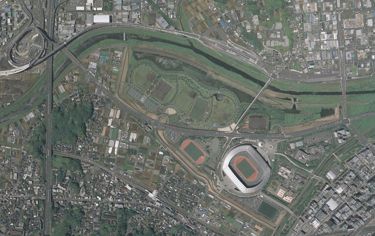 2019年の小机駅周辺の航空写真。小机駅は画面真ん中下の白い建物。田園地帯だったところに、立派な日産スタジアムが出来たことがよく分かる　出典：国土地理院の空中写真