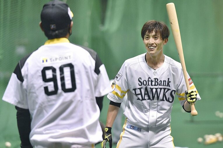 ソフトバンク宮崎キャンプで。小久保ヘッドコーチ（左）から指導を受け、笑顔を見せる周東佑京 ／ photograph by KYODO