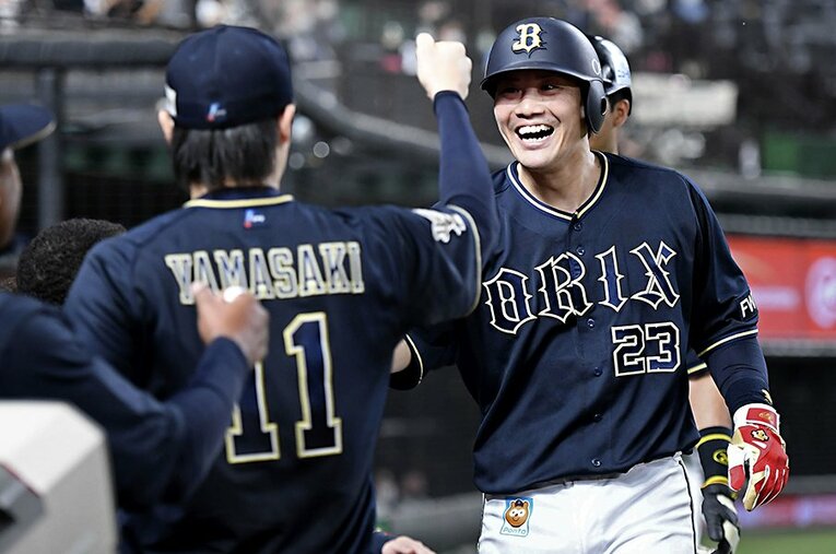 ベンチで左腕・山崎福也に迎えられる伏見寅威（31歳）。プロ9年目の今季、女房役として好調なオリックス投手陣を支えている ／ photograph by KYODO