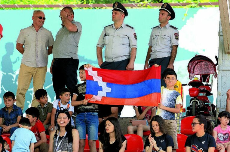 スタンドでアルツァフの国旗を掲げる子どもたち。多大な犠牲を払いながらも、サッカーは日常に戻ってきた ／ photograph by Gevorg Ghazaryan