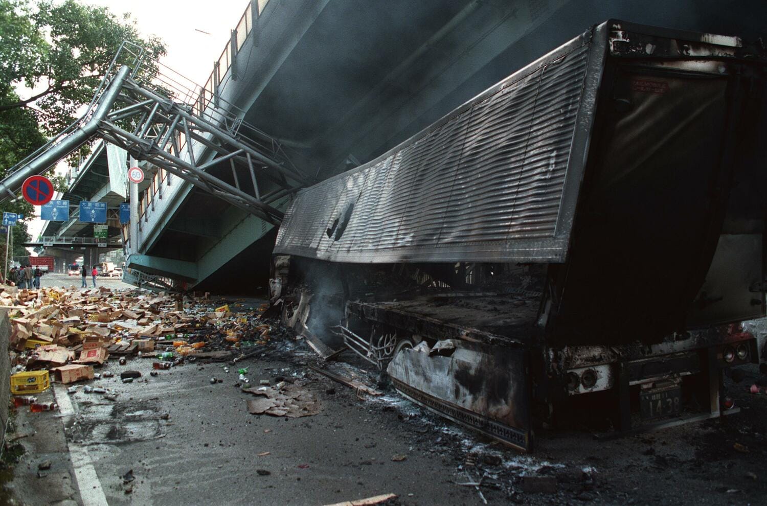 1995年、阪神淡路大震災。甲子園球場近くの阪神高速は崩れ落ち、トラックが押し潰されていた ©︎JIJI PRESS