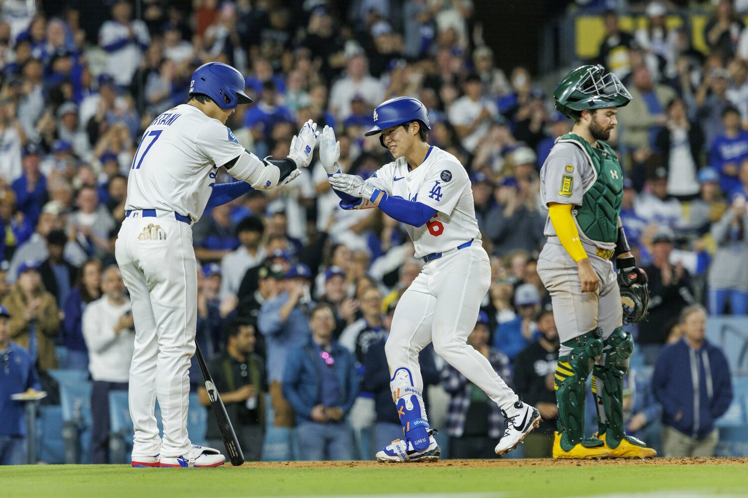 キム・ヘソンのMLB初ホームランを出迎える大谷翔平。握手やタッチの際に手を添える動作は“リスペクト”の意味をこめられている。　©︎Gina Ferazzi / Los Angeles Times via Getty Images