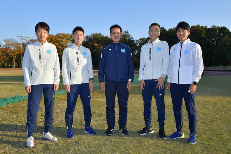 左から、猿橋、大土手、弘山駅伝監督、西、上迫。選手に囲まれ弘山監督の表情も柔らかくなった