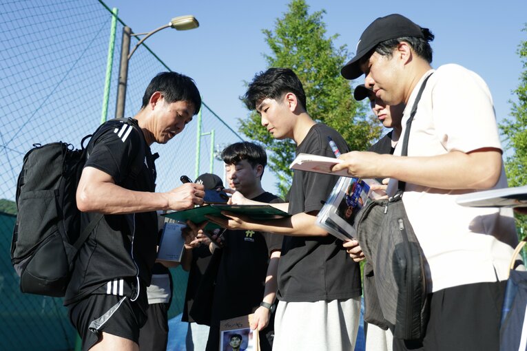 サポーターにサインを書く森保監督　©︎JIJI PRESS
