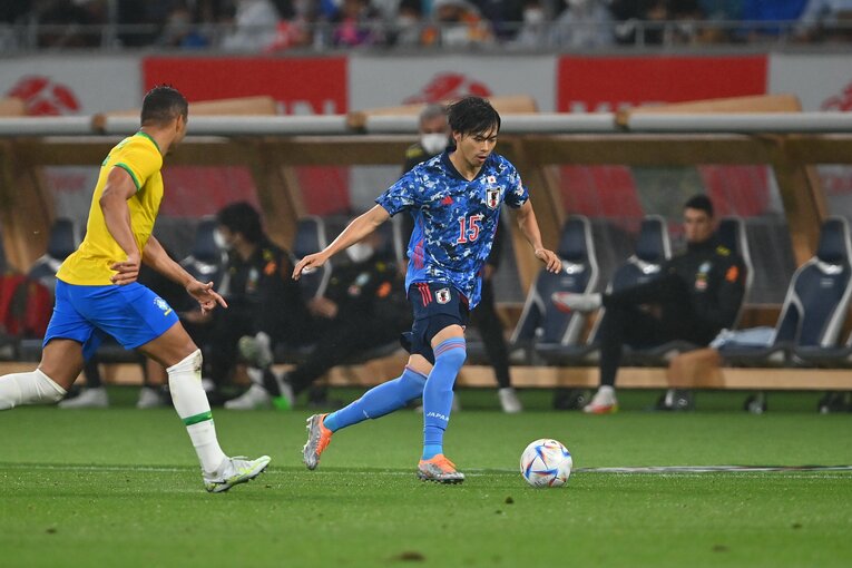 タッチ際でドリブルする三笘薫　©Takuya Kaneko/JMPA