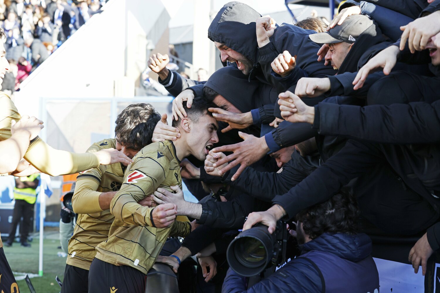 選手、ファンに挟まれ揉みくちゃにされながら撮影を続けるカメラマンの姿も