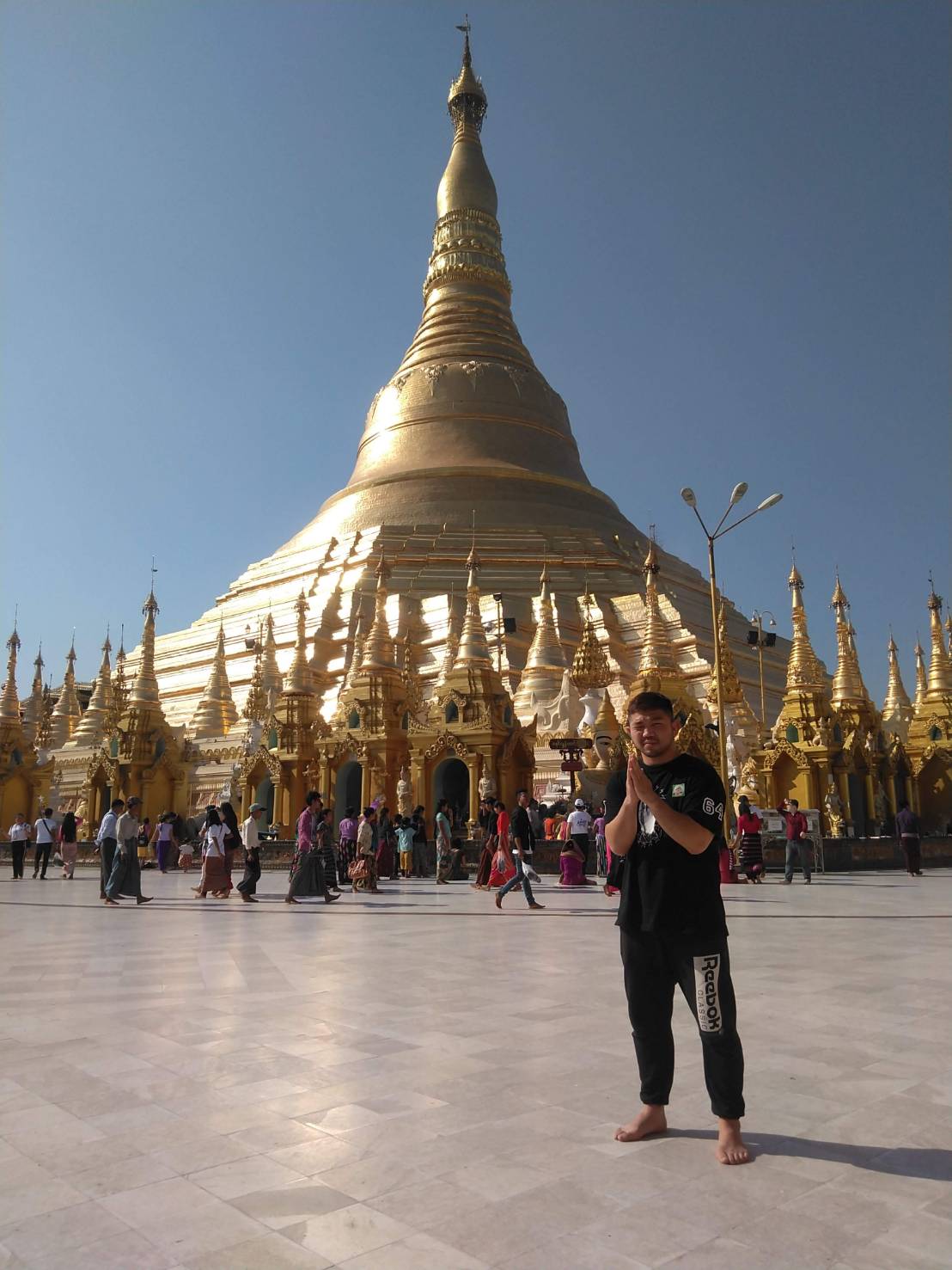 ミャンマーの寺院の前で手を合わせる渡慶次（本人提供）