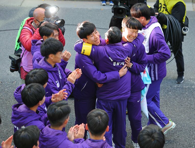 総合優勝を決め、大八木監督の熱いハグに、エース田澤と主将・山野はこの笑顔　©JIJI PRESS