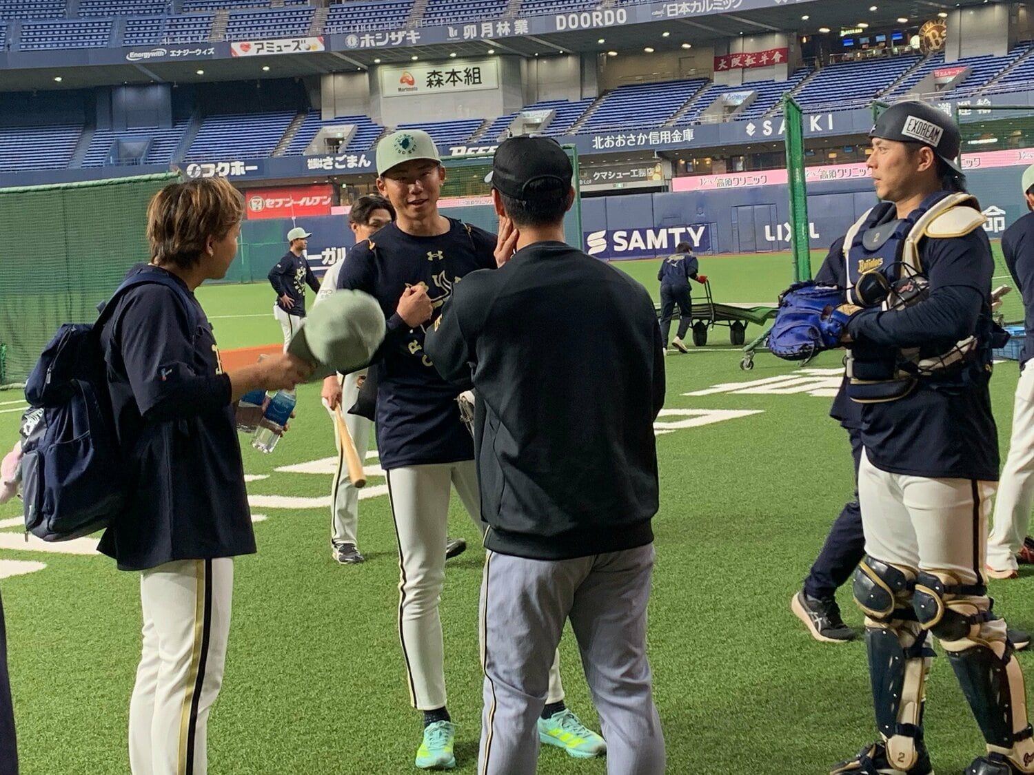 オリックスのベンチ前までやってきた阪神・坂本（手前）と談笑する若月、曽谷、宮城　（写真＝筆者撮影）