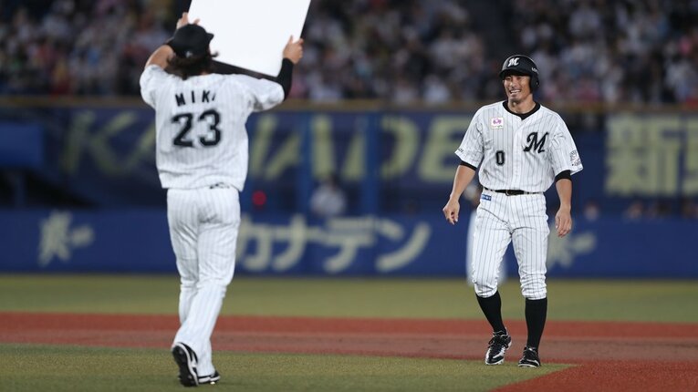 ロッテ三木亮から記念ボードを手渡される荻野貴司　©︎Chiba Lotte Marines