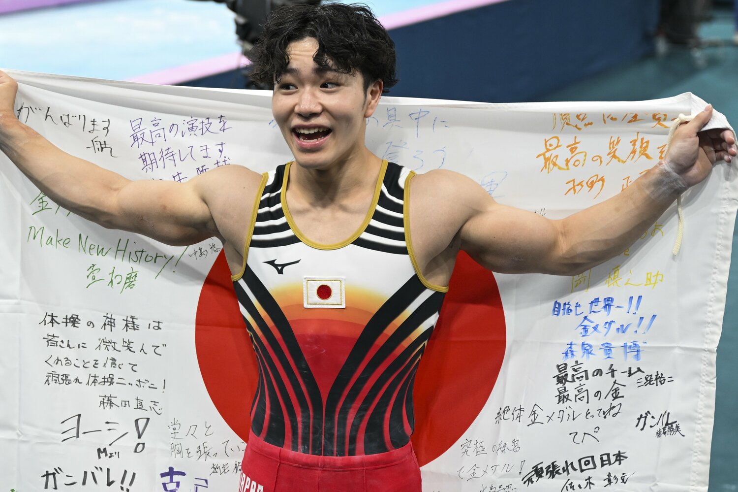 日の丸を掲げ、嬉しそうな笑顔を見せた岡　©Asami Enomoto/JMPA