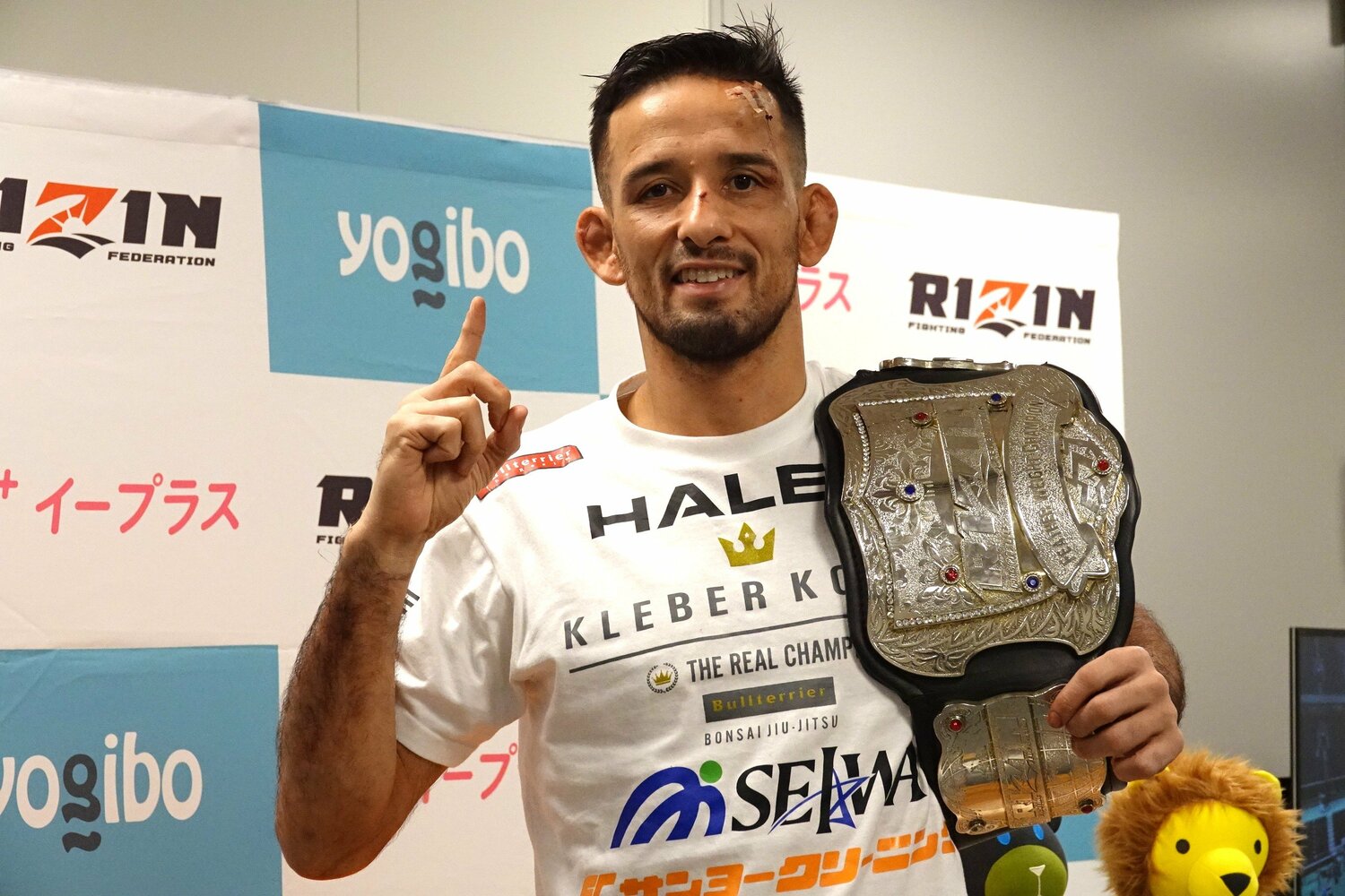 ベルトを肩にかけて笑顔を見せるクレベル・コイケ ©Koji Fuse