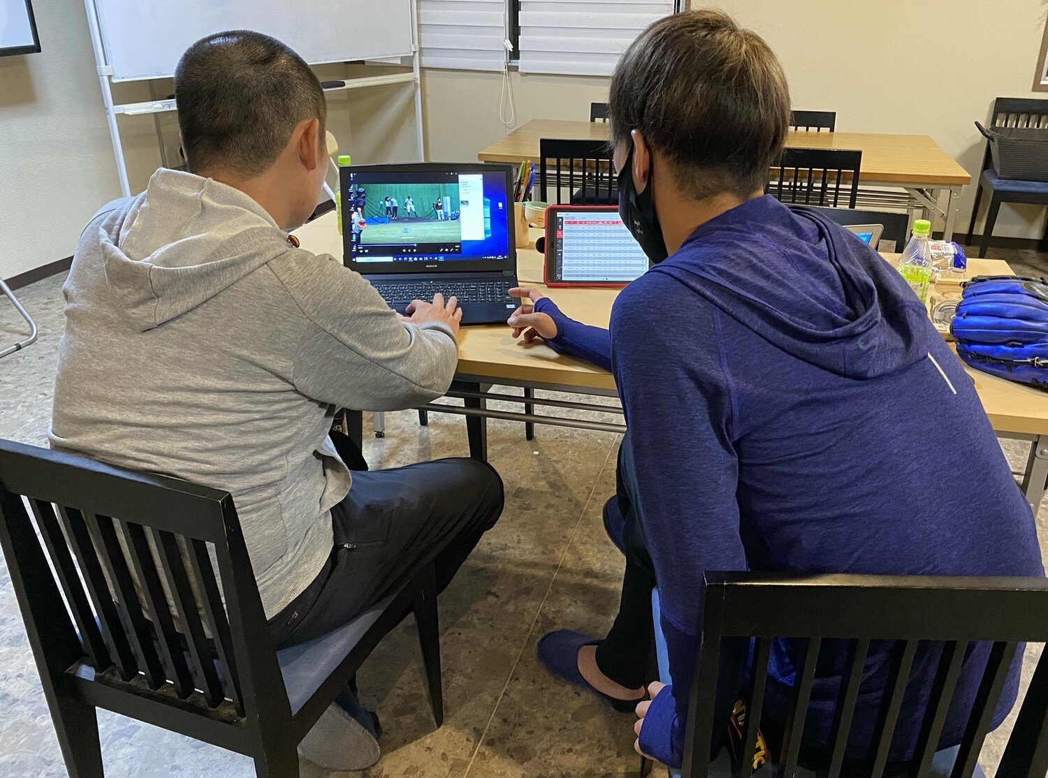 スタッフとともにデータの分析をしている様子。右が小杉（写真=本人提供）