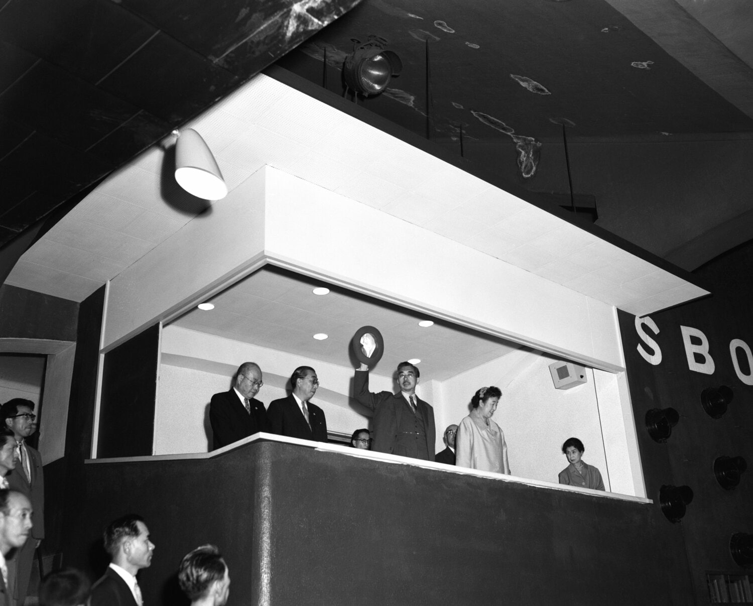 後楽園球場に初めて天皇、皇后両陛下がお出でになり、野球放送解説者・中沢不二雄氏（貴賓席左端）の解説でプロ野球ナイター巨人－阪神戦を観戦。お帰りの際に観衆の歓呼に応えられた　©Kyodo News