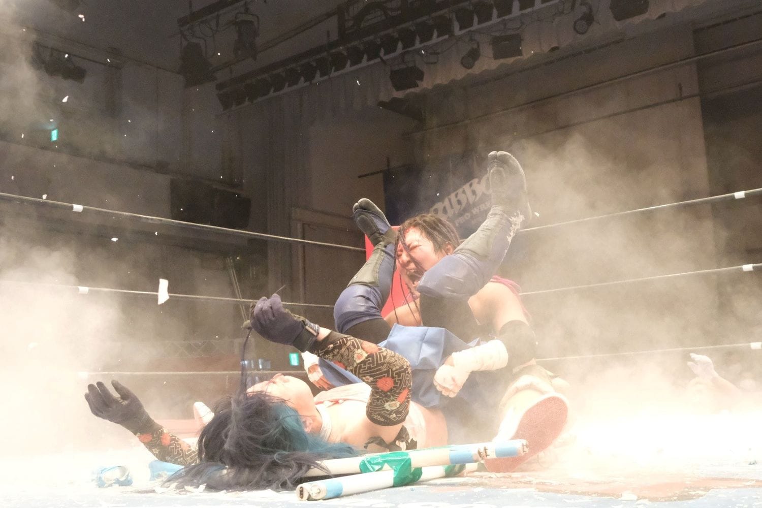 リングは割れた蛍光灯の粉塵に包まれた（クリックすると「この記事の写真」に飛びます。流血等の過激な写真を含みますのでご注意ください）