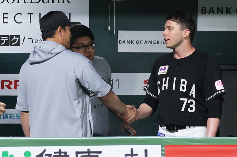 7月4日のソフトバンク戦。７回を投げ切り、サブロー監督と握手するサム・ロング。左隣は村田通訳　©JIJI PRESS