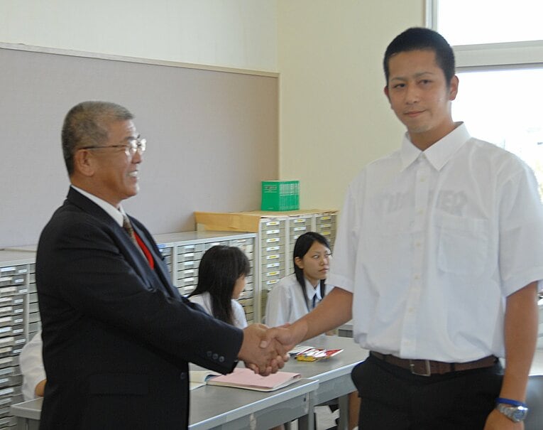 ドラフトの結果を添石邦男校長から伝えられた時の八重山商工・大嶺祐太　©︎JIJI PRESS