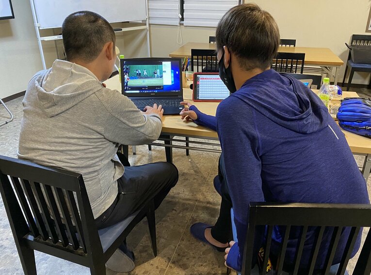 スタッフとともにデータの分析をしている様子。右が小杉（写真=本人提供）