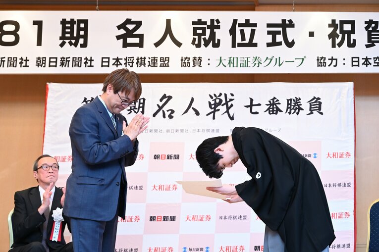 藤井名人に表彰状を渡してパチパチと拍手する羽生会長　©Keiji Ishikawa