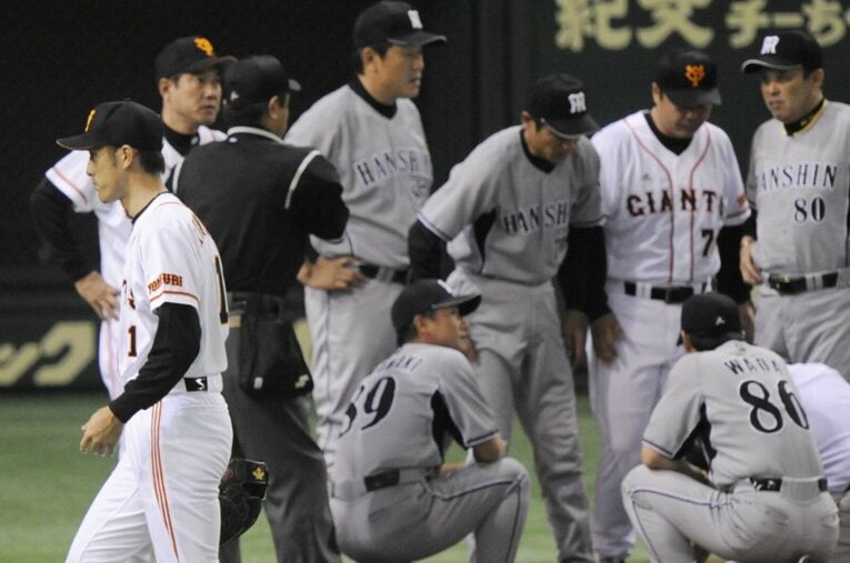 阪神・金本に頭部死球を投じてしまい顔面蒼白のままマウンドを降りる巨人・木佐貫（左） ／ photograph by KYODO