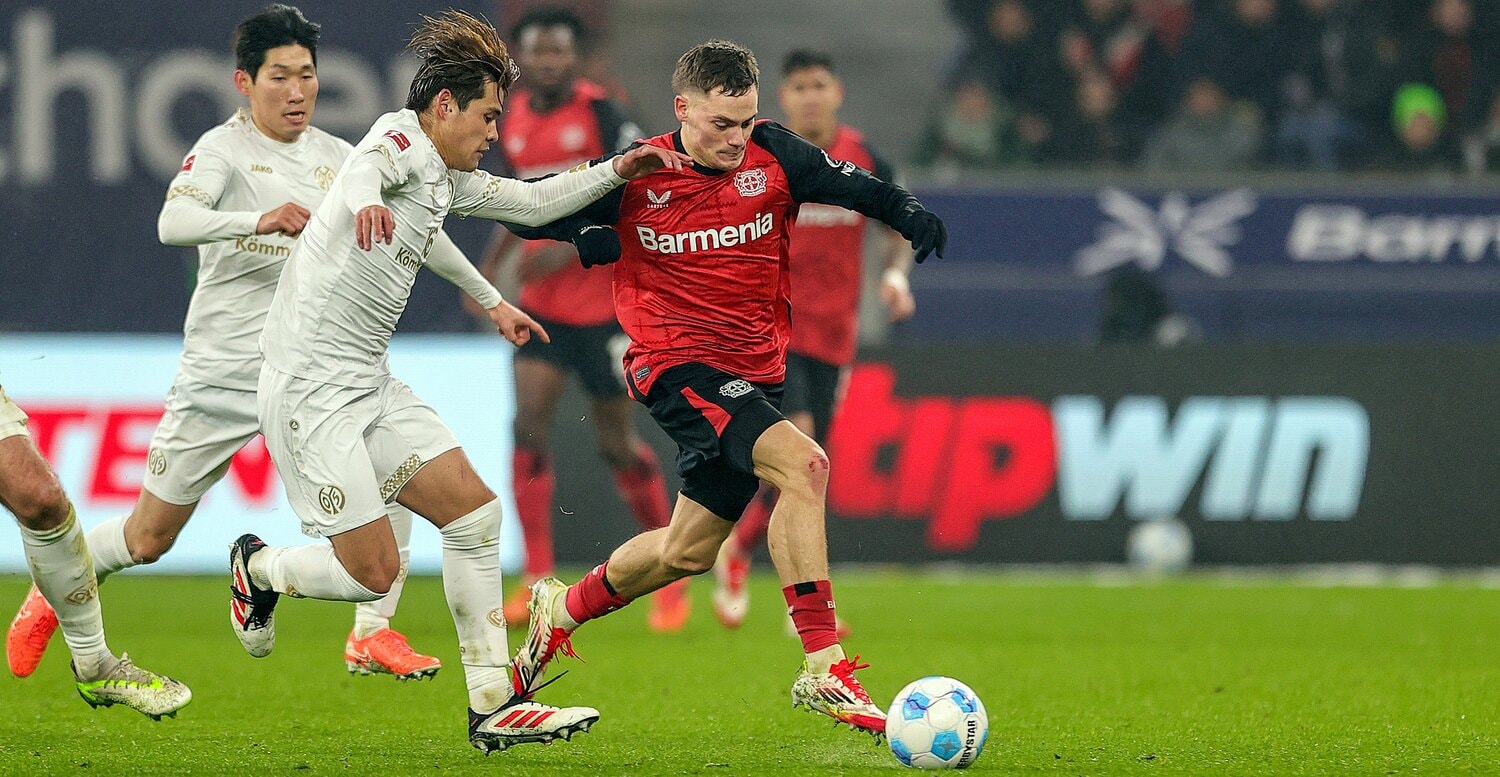 レーバークーゼンのドイツ代表フロリアン・ヴィルツのボールを狙う佐野海舟　©Getty Images