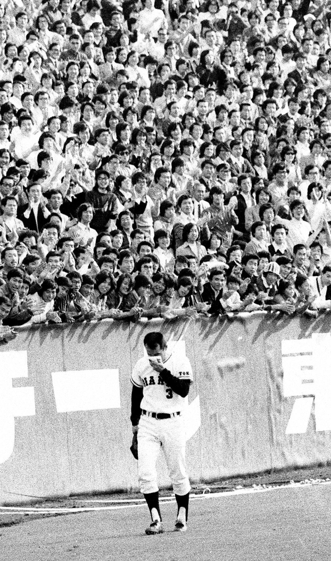 タオルで涙をぬぐいながらファンの声援を背にグランドを1周する長嶋　©KYODO