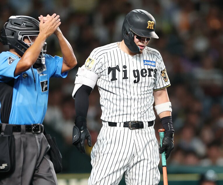 8月30日、巨人戦で死球を受けて顔をしかめる佐藤輝明。これが今季2度目の死球だった　©JIJI PRESS