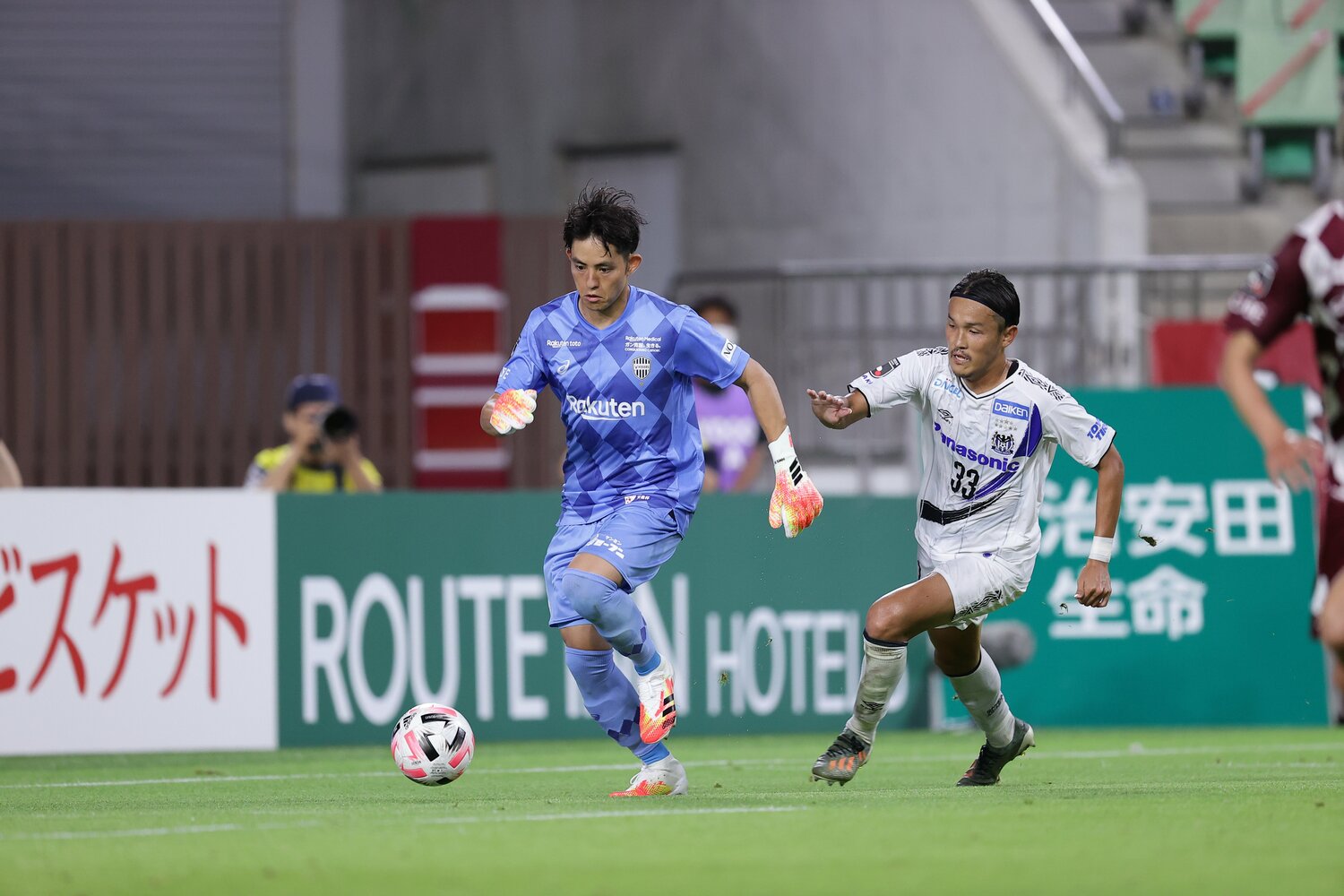 ドリブルで持ち上がるGK榎本と、それを追うガンバ大阪の宇佐美（右）©︎J.LEAGUE