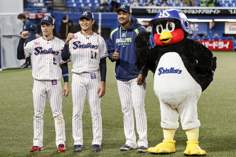 左から2安打1打点の塩見泰隆、奥川、初回に2ランを放ったサンタナ、つば九郎　©Kiichi Matsumoto