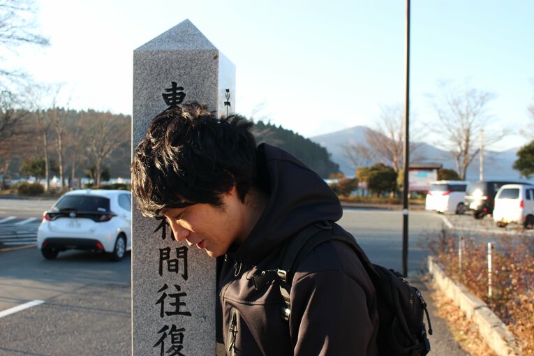 ゴール地点の石柱に体を擦り寄せる筆者　©Number Web