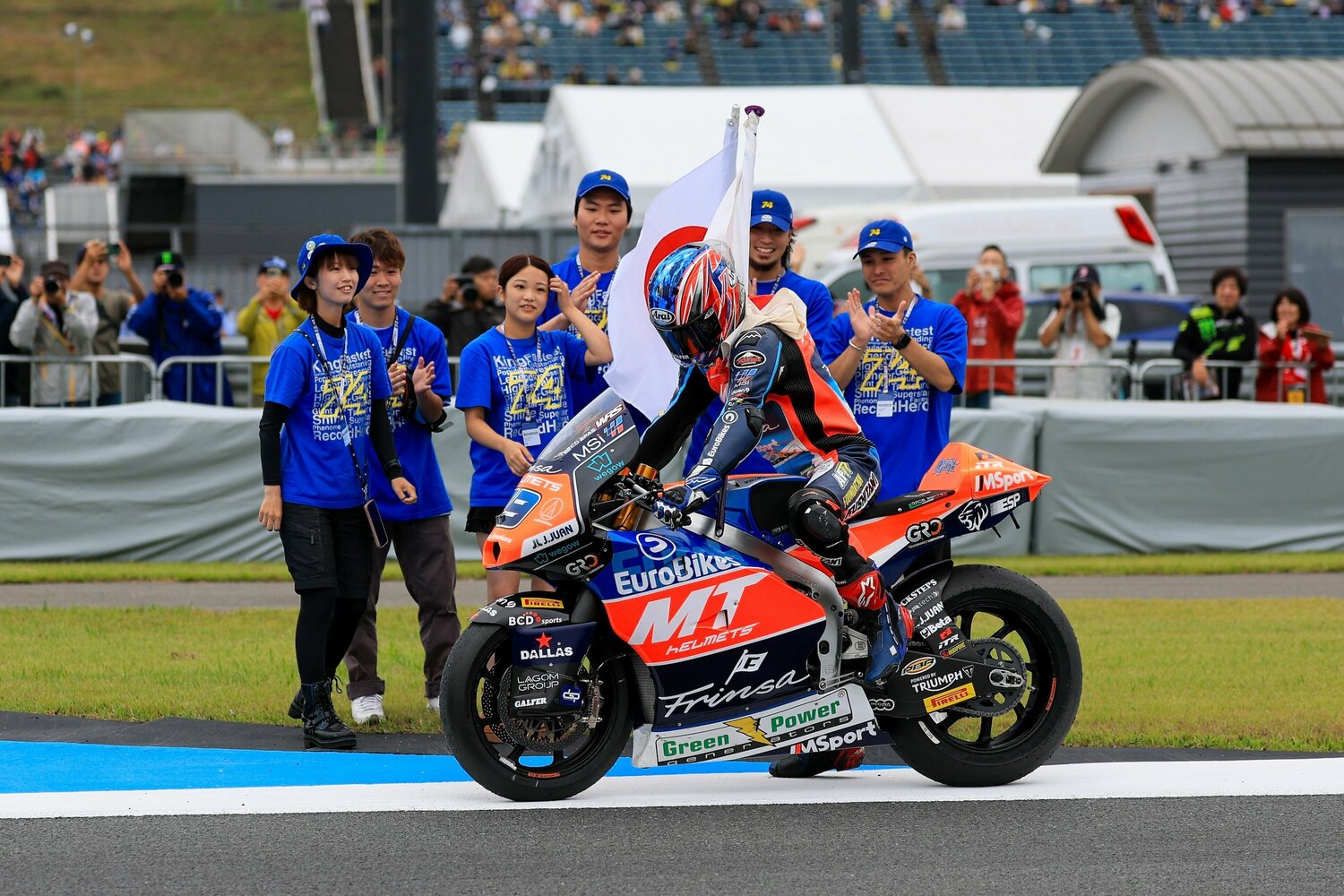 フィニッシュ後、加藤大治郎の長女・凛香さん(左から3番目)から日章旗を受け取る小椋 ©Satoshi Endo