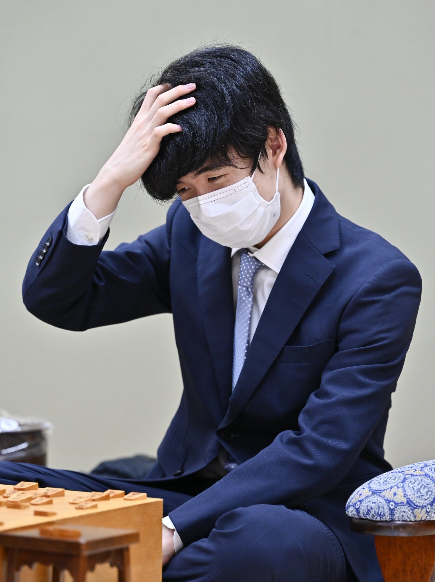 9月17日、棋王戦本戦トーナメント3回戦で斎藤慎太郎八段に敗れ、頭を抱える藤井三冠。これが通算46敗目だった ©KYODO