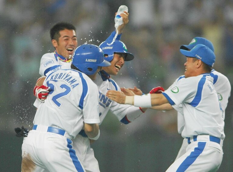 サヨナラタイムリーを放った赤田将吾（中央）に水をかけて祝福する西武ナイン。左手前は同点打の栗山巧（2006年７月）　©JIJI PRESS