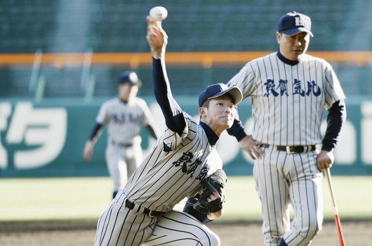 2016年センバツで山崎颯一郎（左）の投球練習を見守る敦賀気比・東哲平監督 ／ photograph by KYODO