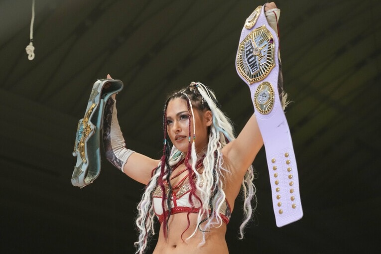 2本のベルトを掲げるジュリア　©Essei Hara