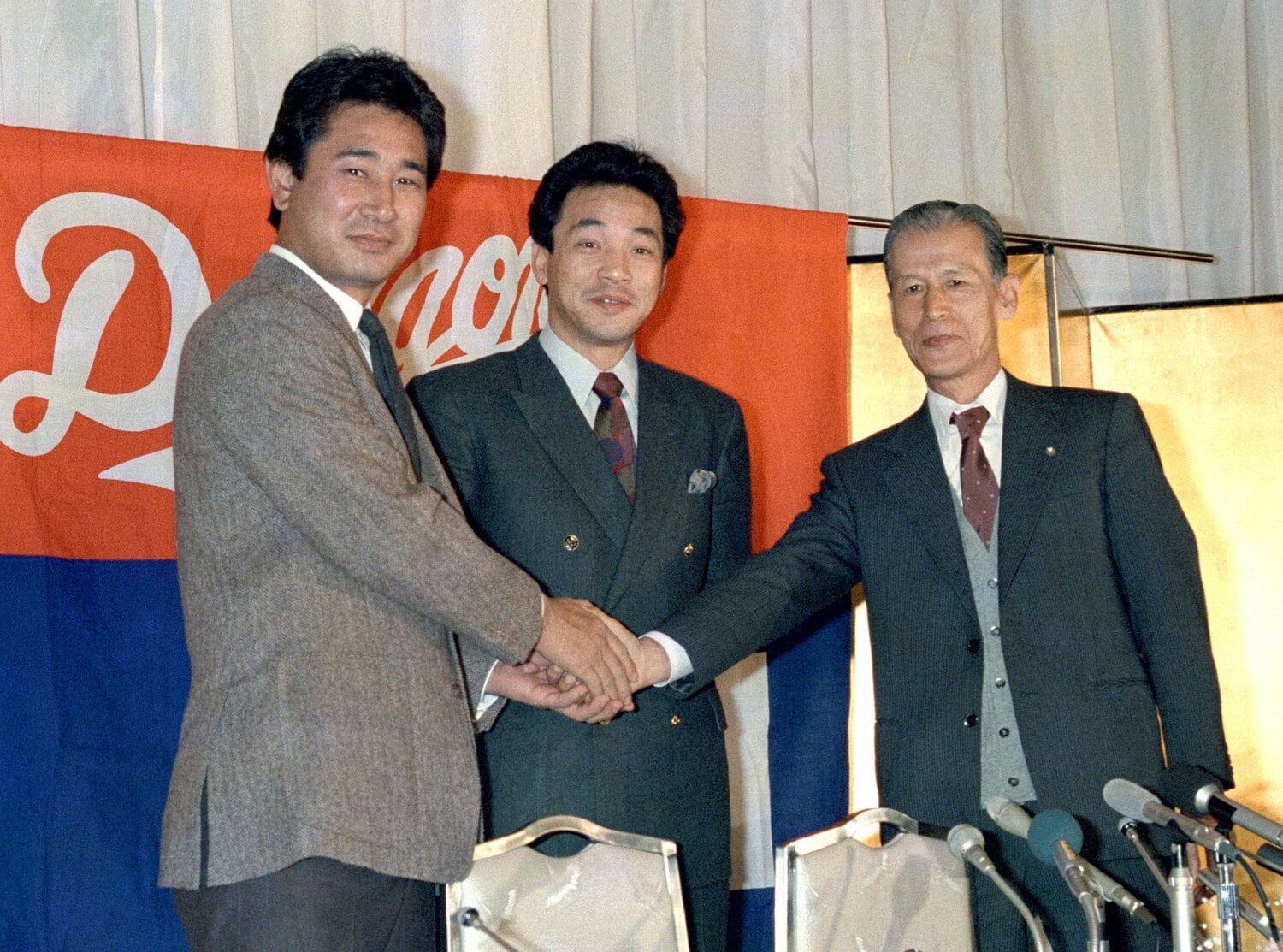 中日へのトレードが正式決定した直後、星野監督（左）や中山球団社長と握手する落合　©Kyodo News