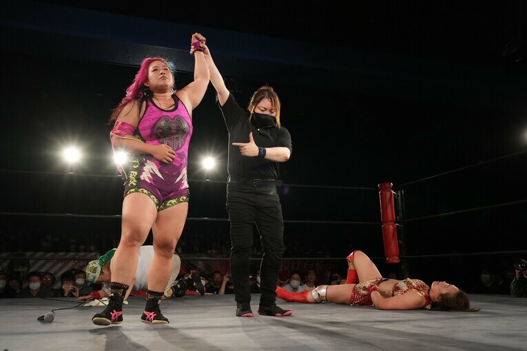 勝ち名乗りを受ける橋本千紘と、リングに横たわるSareee