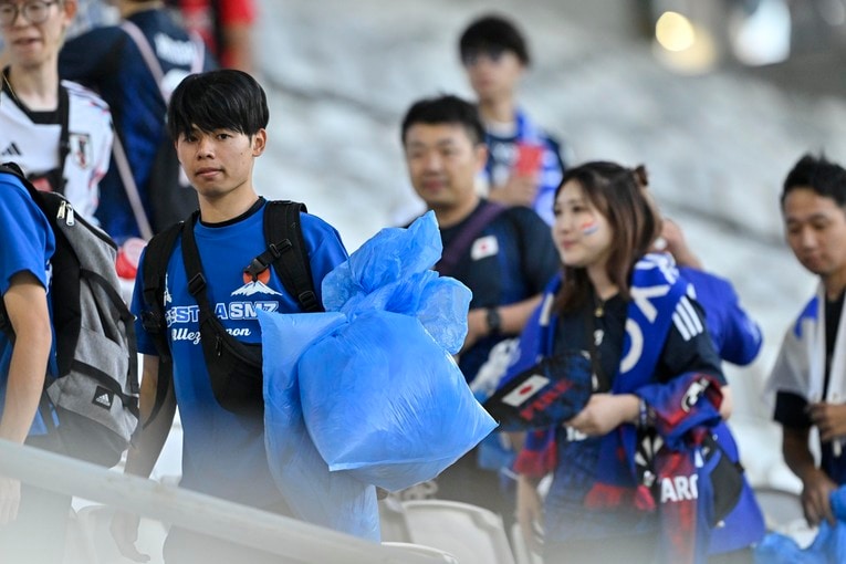 ゴミ拾いする日本サポーター　©Takuya Nakachi/JMPA