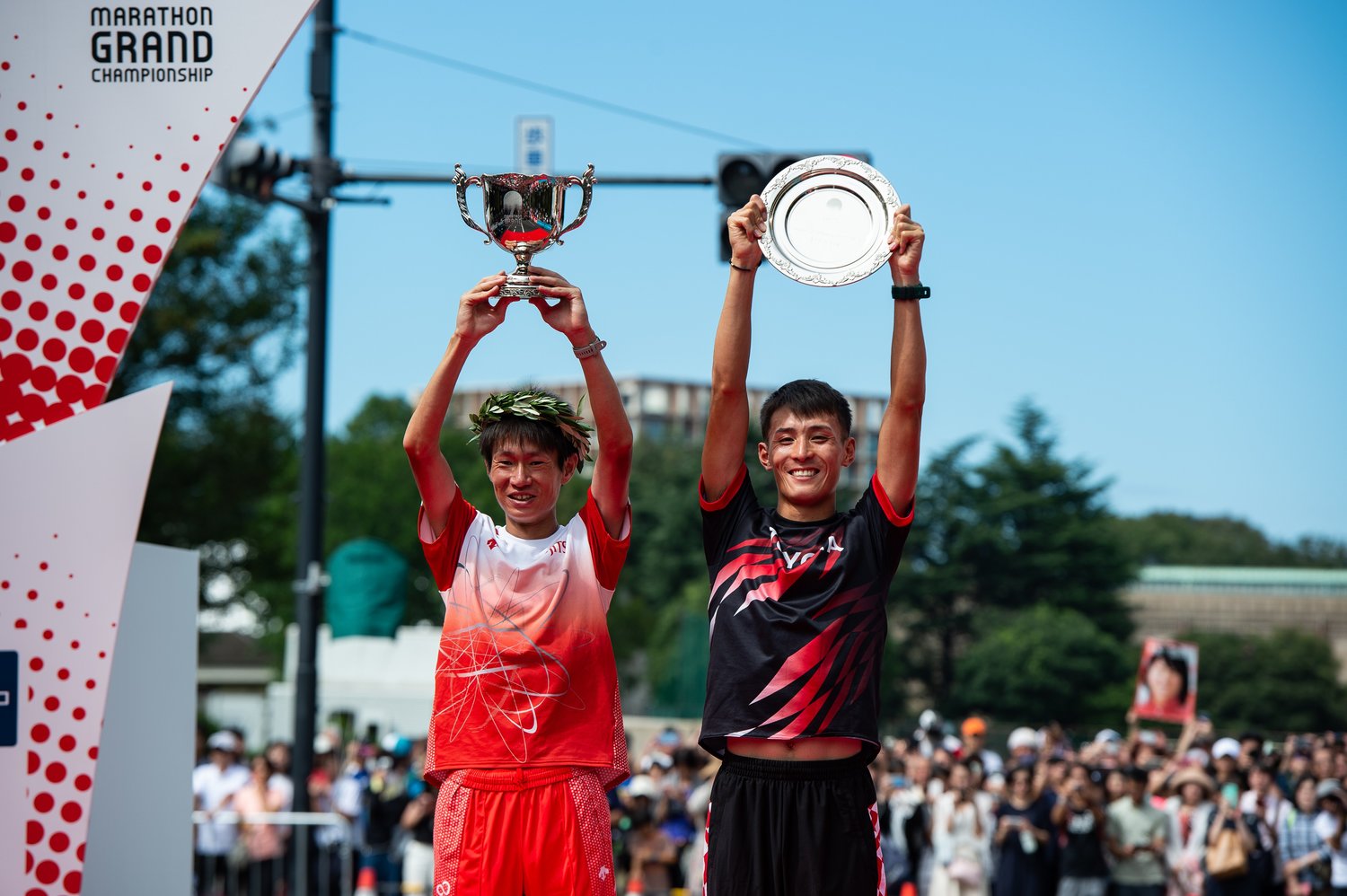 昨年のMGCでトロフィーを掲げる、（左から）中村匠吾と服部勇馬　©Takuya Sugiyama