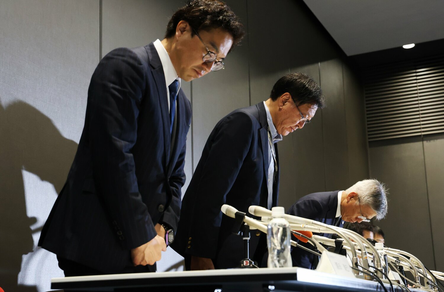 7月19日、記者会見で頭を下げる日本体操協会の藤田直志会長（奥）ら　©JIJI PRESS