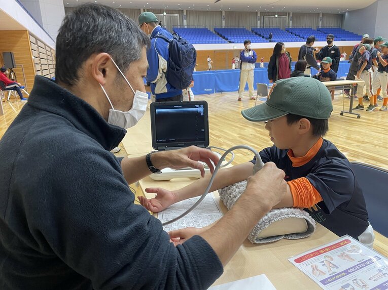 医師による肘検診の様子　©︎Ayako Oikawa