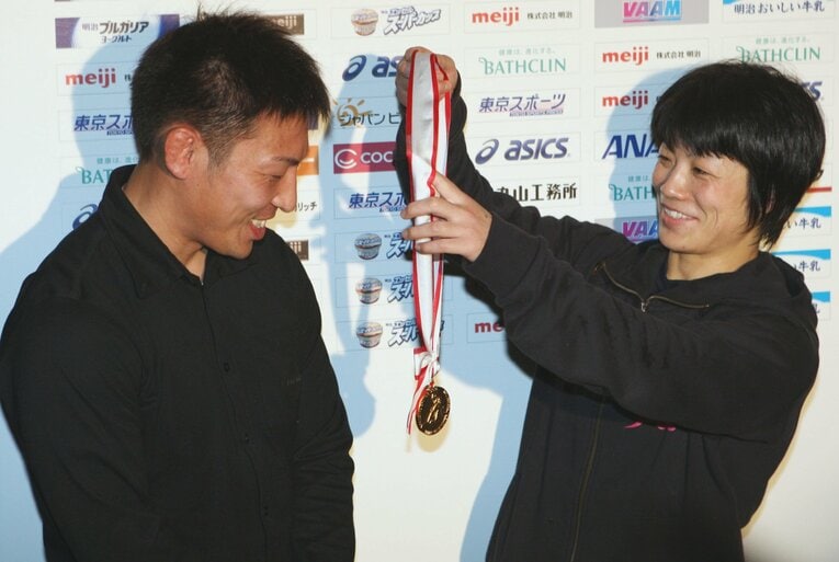 夫の康司さんに世界選手権金メダルをかける小原さん（2011年）©JIJI PRESS