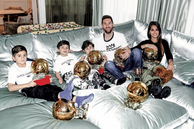 パリの自宅リビングで家族と7つのトロフィーとともに撮影に応じたメッシ ／ photograph by L’Équipe