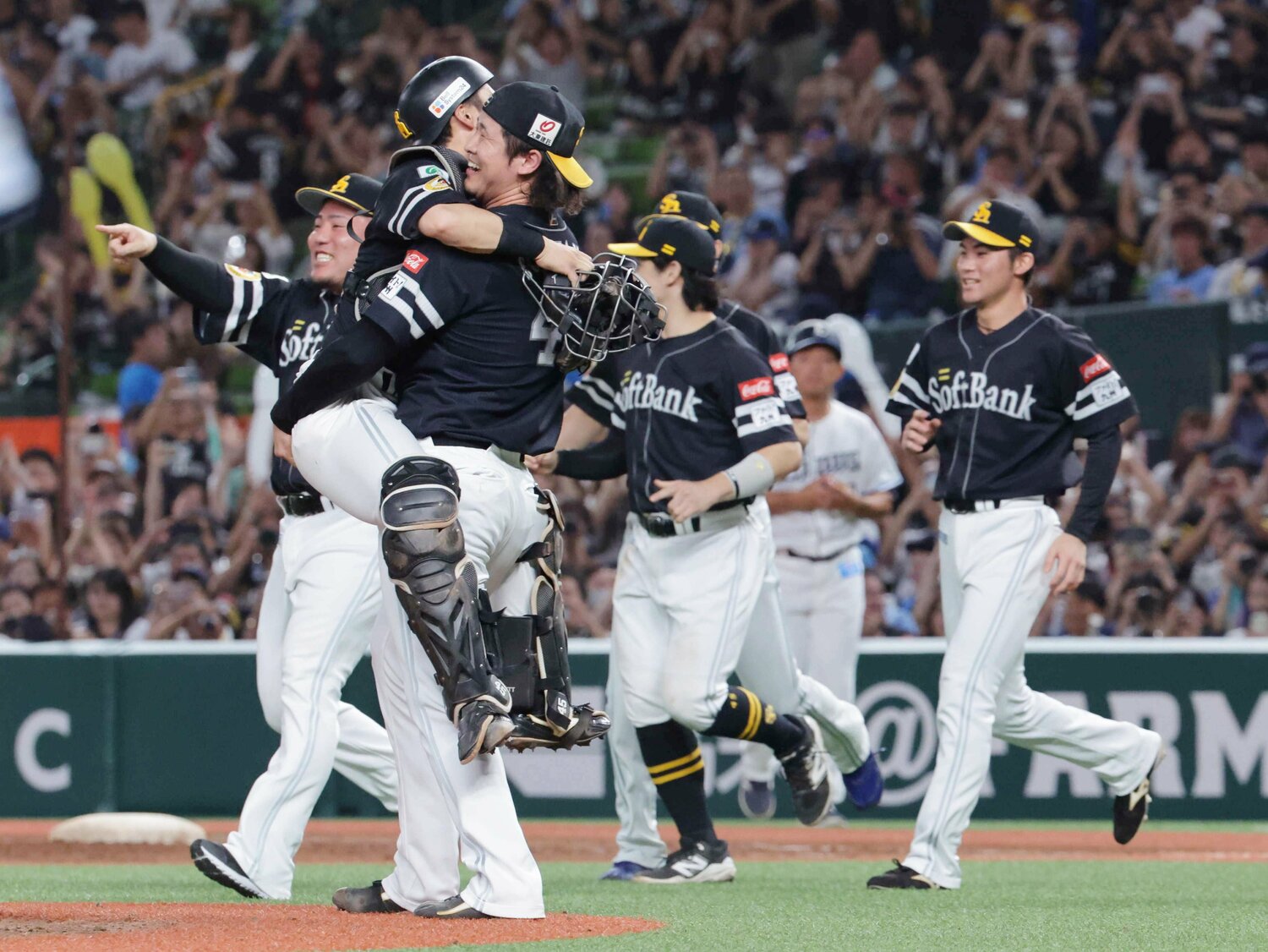 レギュラーシーズンの連覇を果たし、捕手の海野隆司を抱き上げて喜ぶ杉山　©JIJI PRESS